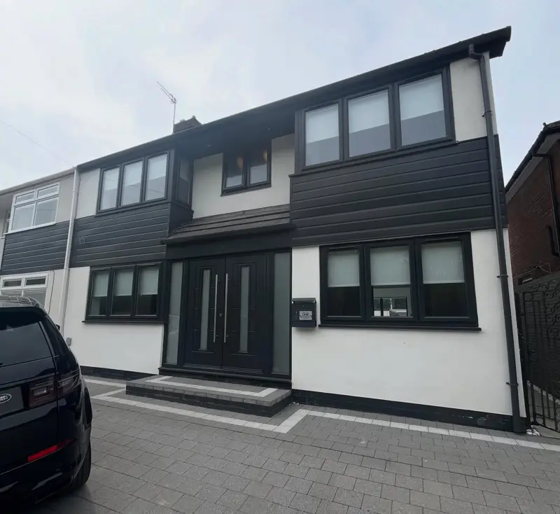 Modern house finished in white render with dark cladding