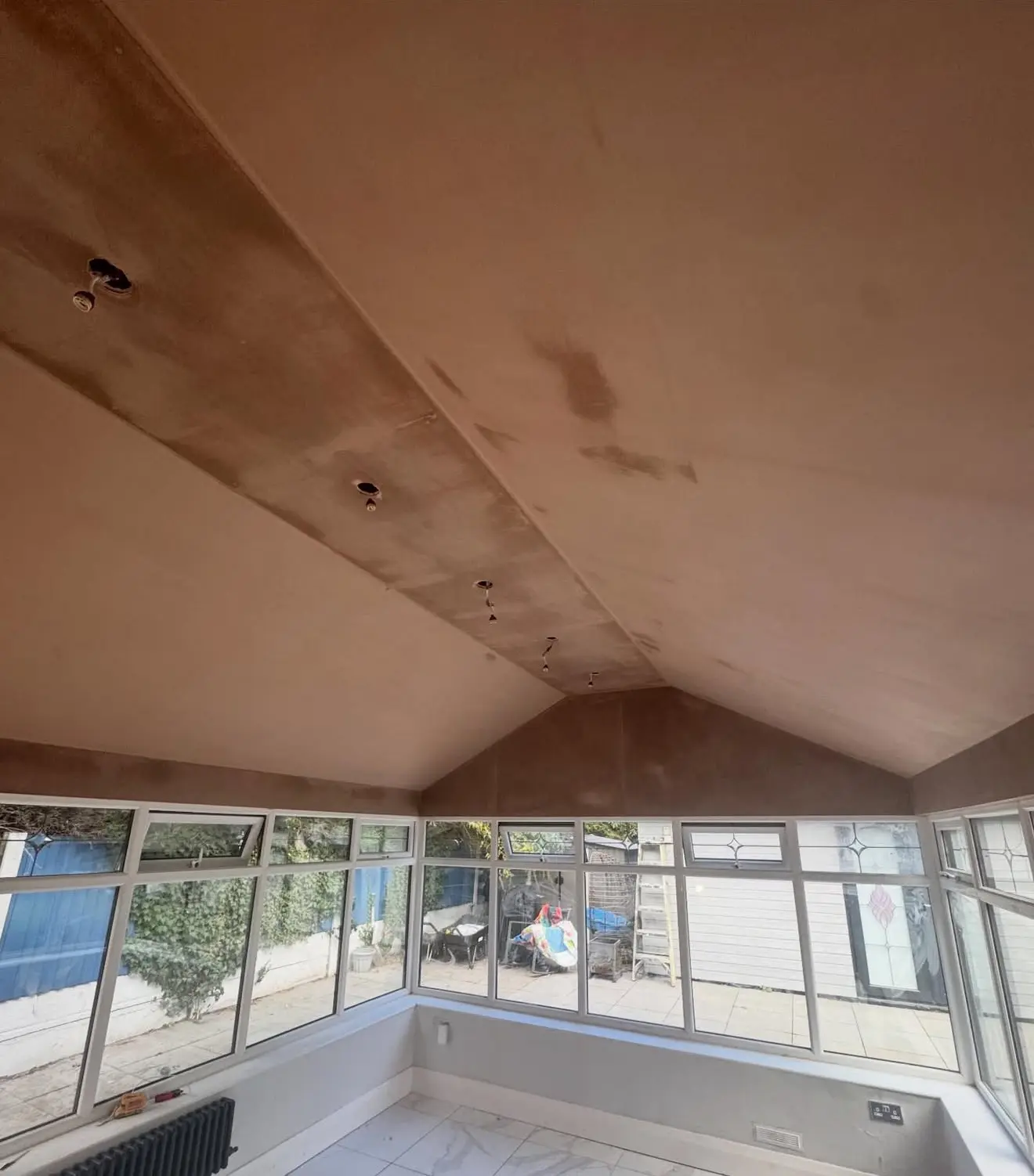 Vaulted ceiling plastered above a run of windows