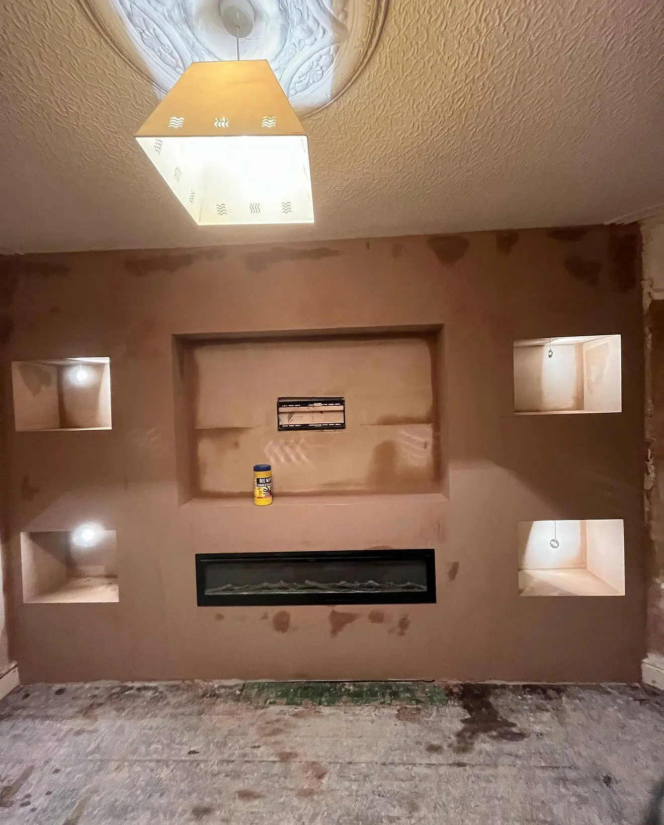 Finished plastered media wall with lit alcoves and fire recess