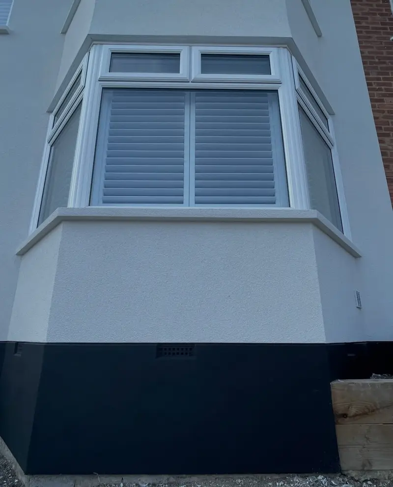 Render detail with a dark plinth around a bay window