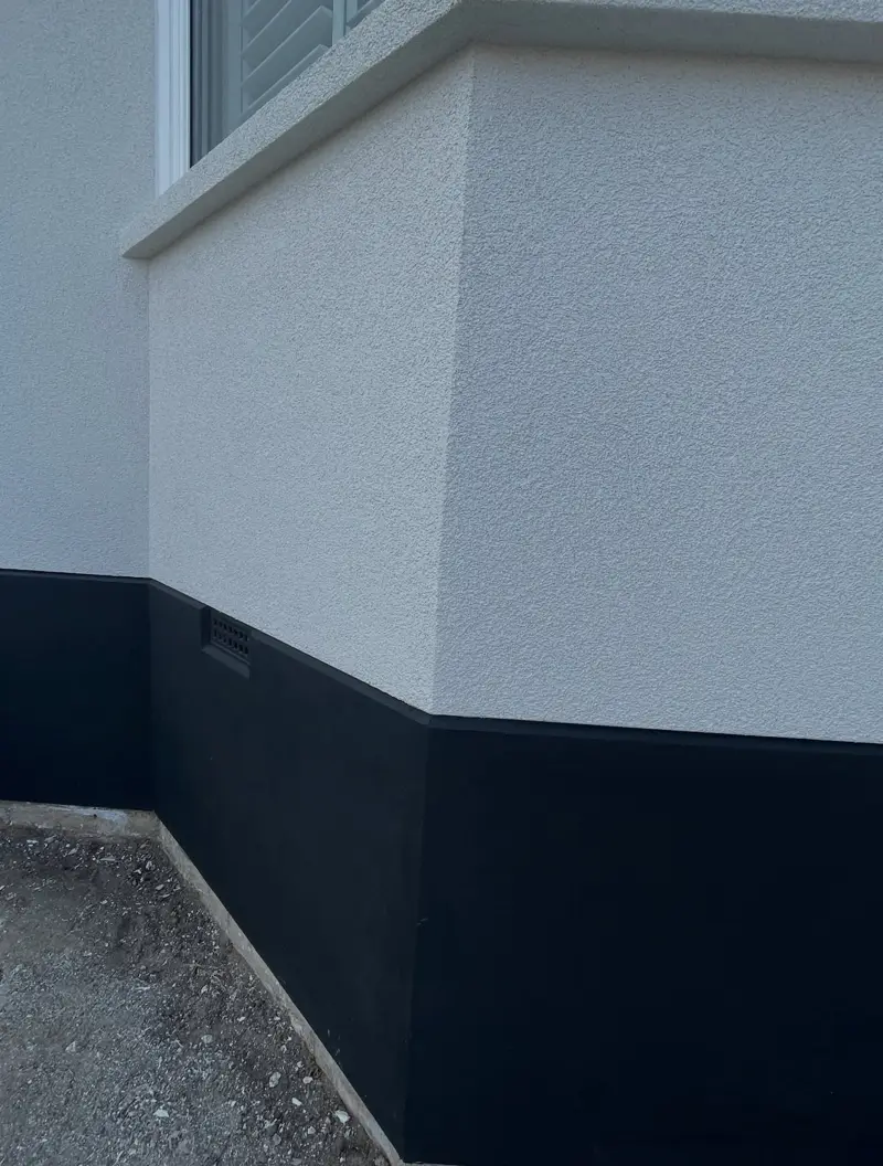 Render detail with a dark plinth around a bay window