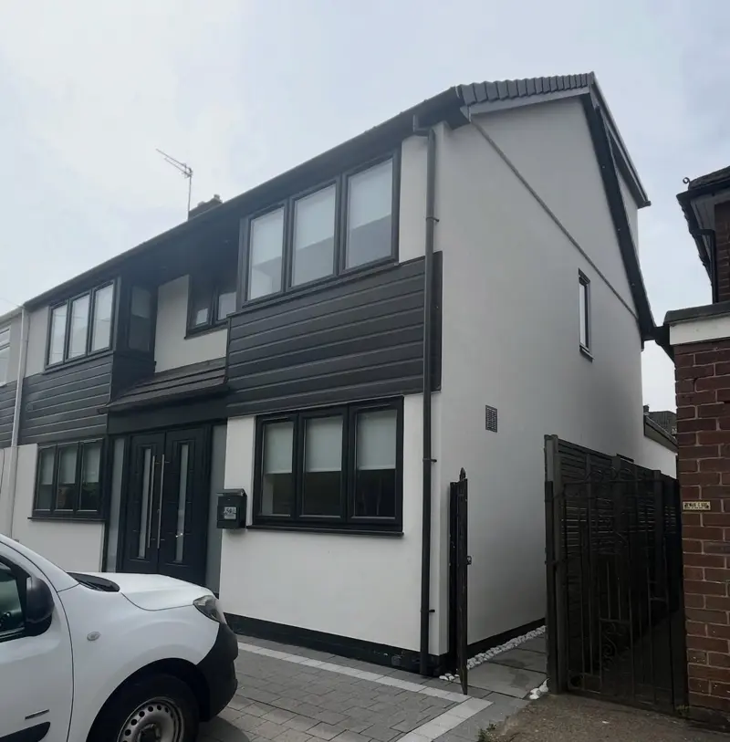 Modern house finished in white render with dark cladding