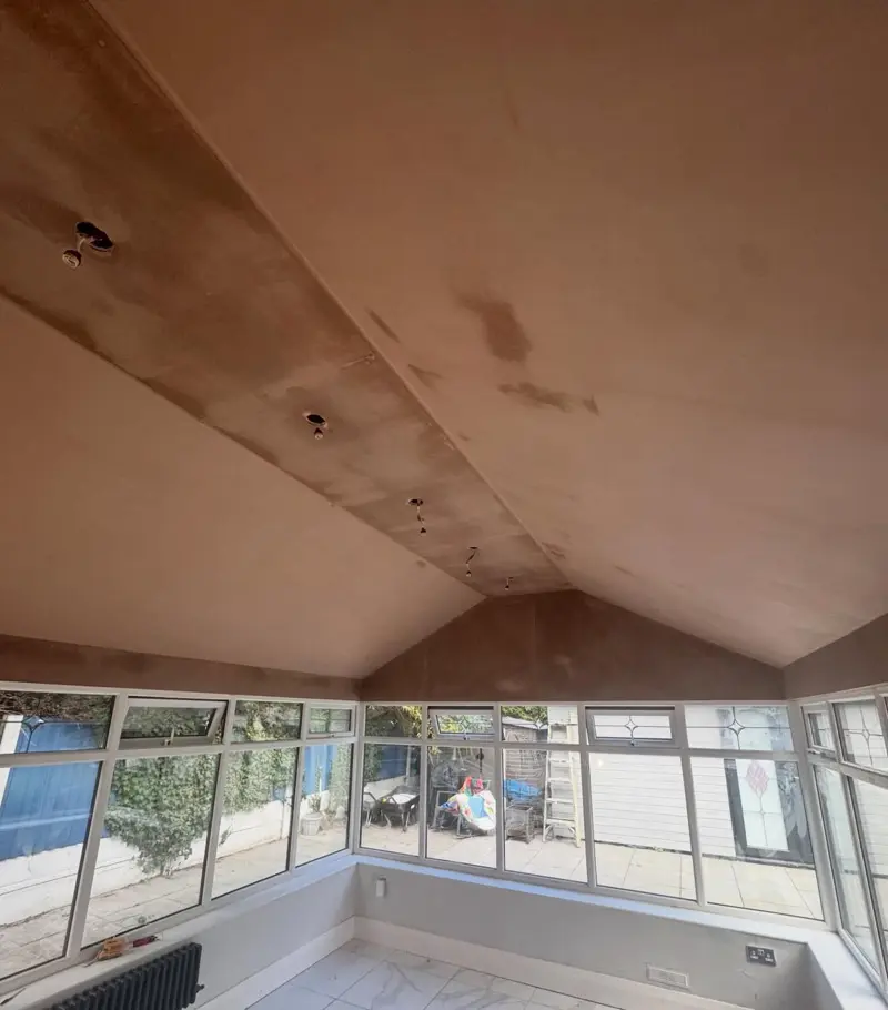 Vaulted ceiling plastered above a run of windows